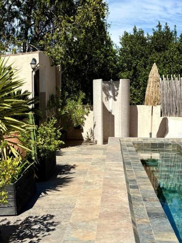 a garden with a swimming pool next to a fence at La Villa Dune, Hôtel & Spa in Saint-Tropez