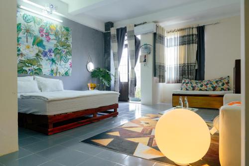 a bedroom with a bed and a living room at Bụi Hostel - Ferry to Rạch Giá in Rach Gia