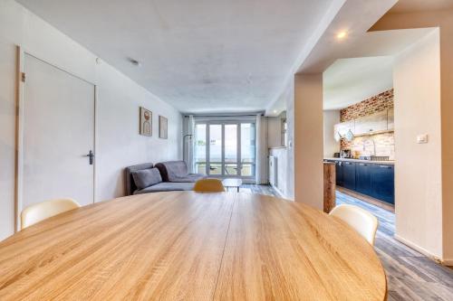 a large wooden table in a living room with a couch at Le petit nid Rémois - Parking - King size in Reims