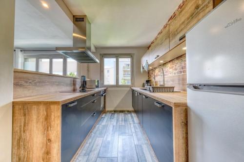 - une cuisine avec parquet et appareils en acier inoxydable dans l'établissement Le petit nid Rémois, à Reims