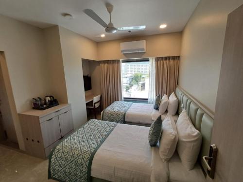 a hotel room with two beds and a window at Hotel 24K Nagpur in Nagpur