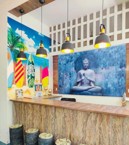 a bar with a mural of a buddha on the wall at Le Majestic Serenity Inn in Puducherry