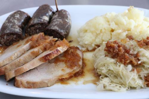 a white plate of food with meat rice and vegetables at Govc-Vršnik in Solčava