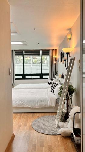 a bedroom with a large white bed and a window at With Hongdae in Seoul