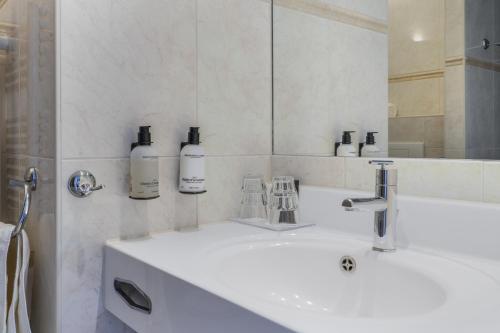 a bathroom with a white sink and a mirror at Paal 8 Hotel aan Zee in West aan Zee