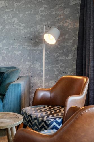 a room with two chairs and a table and a lamp at Paal 8 Hotel aan Zee in West aan Zee