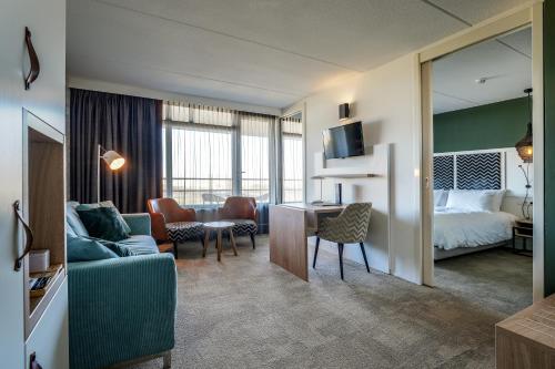 a hotel room with a bed and a living room at Paal 8 Hotel aan Zee in West aan Zee