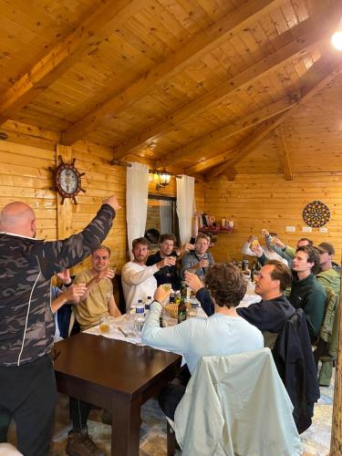 a group of people sitting around a table in a room at Thethi Paradise Hotel & Restaurant in Theth