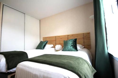 - 2 lits avec des oreillers verts dans une chambre dans l'établissement Appartement 6P place toscane, Disneyland, à Serris