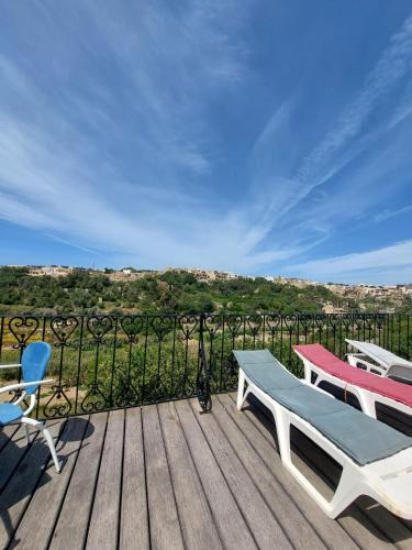 a deck with two chairs and a bench on it at Poolside Paradise, Private comfort, stunning views, and effortless self checkin in Għajn il-Kbira