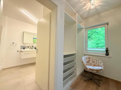 a dressing room with a chair and a window at Casa Braun in Bodman-Ludwigshafen