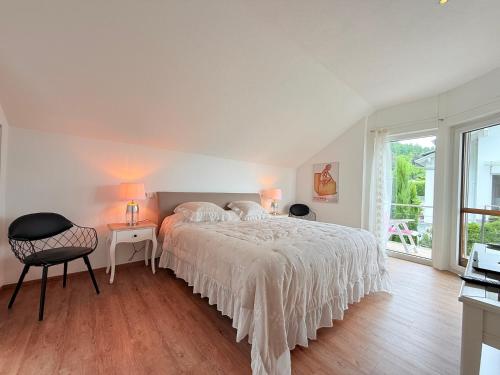 a bedroom with a bed and a table and a chair at Casa Braun in Bodman-Ludwigshafen