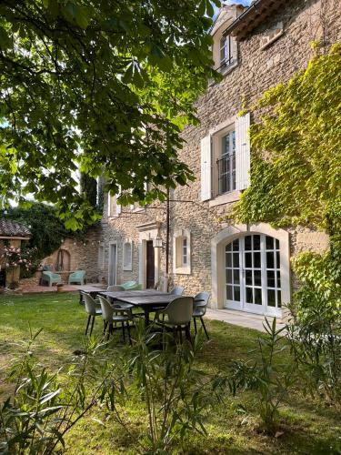 a table and chairs in front of a stone house at Le Moulin de Montségur in Montségur-sur-Lauzon