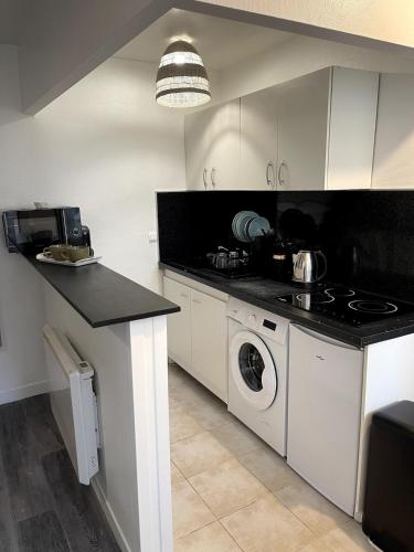 Il comprend une cuisine équipée d'une cuisinière et d'un lave-linge/sèche-linge. dans l'établissement 1 apartement en centre ville, à Nogent-sur-Oise