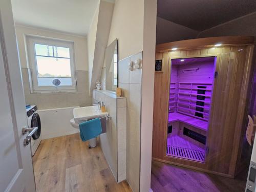 ein Badezimmer mit einer lila Dusche und einem Waschbecken in der Unterkunft Ferienhaus Liv in Biendorf