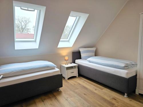 two beds in a room with two windows at Ferienhaus Xena in Biendorf
