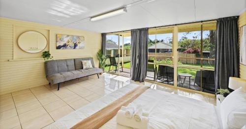 ein Wohnzimmer mit Couch und großem Fenster in der Unterkunft Private King Bed, Walk To Beenleigh Village&Museum Bedroom3 in Yatala