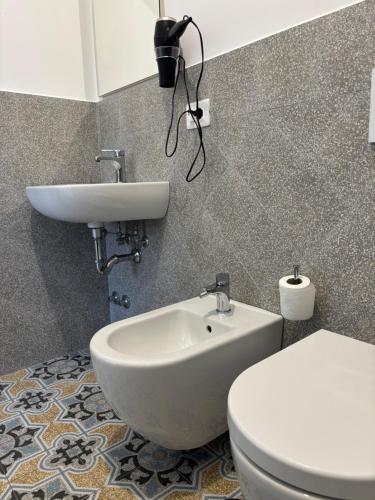 a bathroom with a white toilet and a sink at La Perla dei Gemelli in Agerola