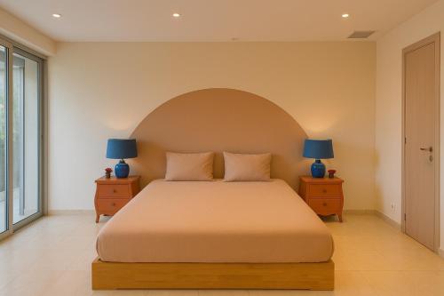 a bedroom with a large bed with two blue lamps at La Villa Saint Jean BAS DE VILLA in La Ciotat