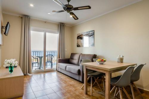 a living room with a couch and a table at Apartamentos Blancala in Cala Blanca