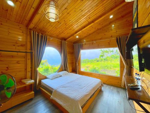 a bedroom with a bed and a large window at Sunset Homestay Villa Tam Đảo in Tam Ðảo