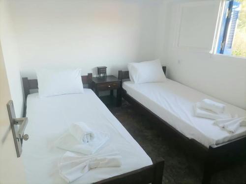 a room with two beds with towels on them at Γκαρσονιέρα δίπλα στην θάλασσα κ θέα στο λιμανι in Évdhilos