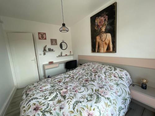 una camera da letto con un letto e un quadro sul muro di Superbe appartement à 5min du centre-ville a Dinan