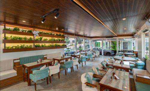 een restaurant met houten plafonds en tafels en stoelen bij B Town Resort Kakkanad Kochi in Cochin