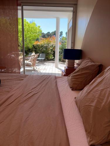 a bedroom with a bed and a view of a patio at La Villa Saint Jean BAS DE VILLA in La Ciotat