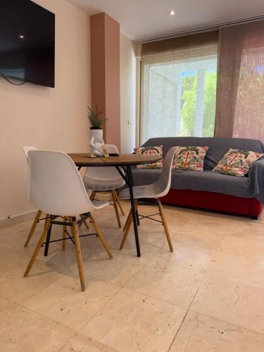 a living room with a table and chairs and a couch at La Villa Saint Jean BAS DE VILLA in La Ciotat