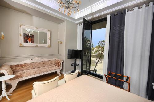 a dining room with a couch and a window at Sea Pearl Apartments in Vlorë