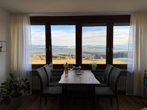 シャイデックにあるFerienwohnung Alpenview im Allgäuの大きな窓のある部屋にあるテーブルと椅子
