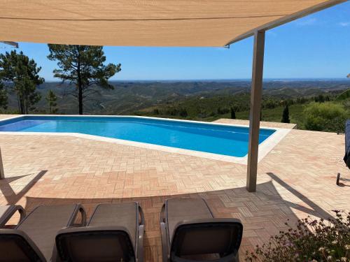 a patio with chairs and a swimming pool at B&B Quinta O Ninho in Monchique