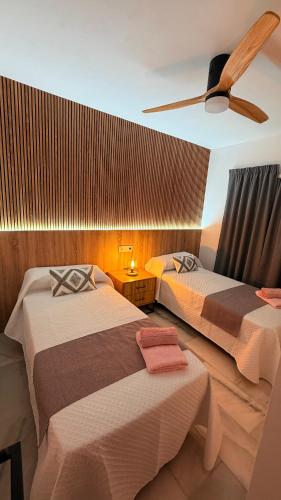 a bedroom with two beds and a ceiling fan at Casa Oasis in Nerja