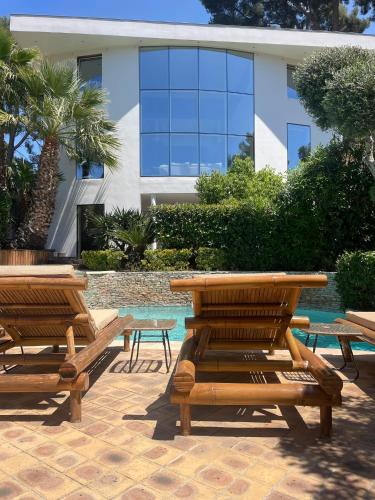 two wooden benches and tables in front of a building at La Villa Saint Jean BAS DE VILLA in La Ciotat