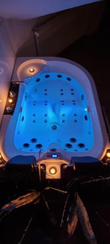 a bathtub with a blue light on top of it at Jacuzzi Katowice chill room in Katowice