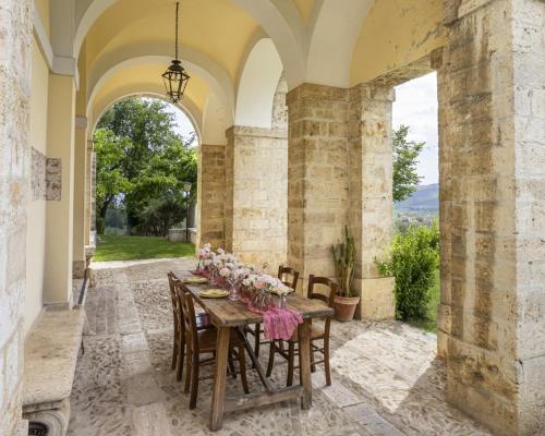 a dining room with a table with flowers on it at Entire Private Floor in an 1800s Frescoed Villa with Historic Park - Villa Mastrangelo in Colli del Tronto