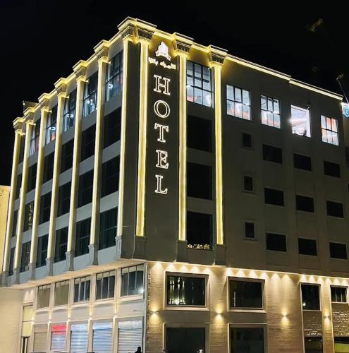 a building with a lit up sign on top of it at فندق الأمراء بلازا in Ma‘ān