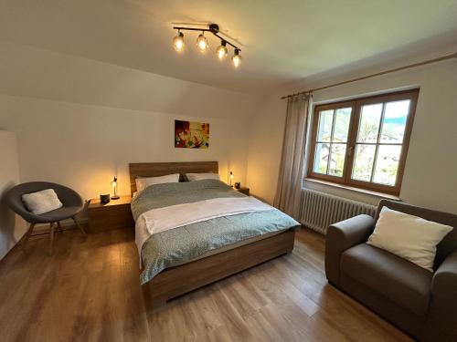 Un dormitorio con una cama, una silla y una ventana en Apartma Vrbnjak, en Bohinj