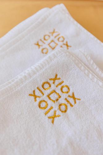 a white napkin with gold embroidery on it at XIO Apartments in Bar
