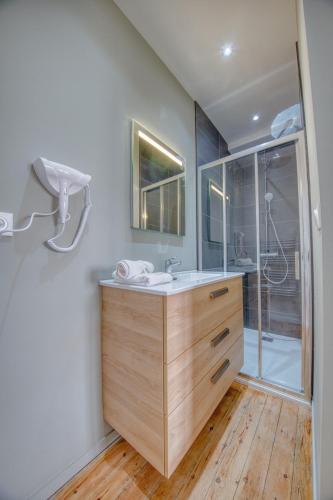 une salle de bain avec un lavabo et une douche dans l'établissement Fleurs d'Azur, à Reims