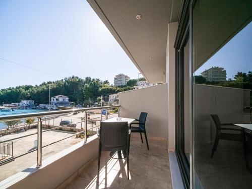 a balcony with tables and chairs and a view of the water at Endless Blue Himara in Himare