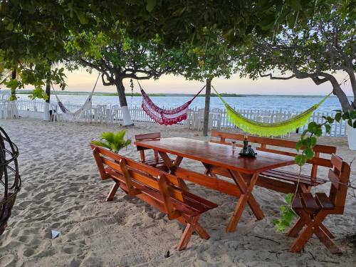 a picnic table and hammock on the beach at Pousada o Forte in Mangue Sêco