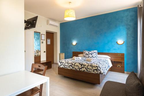 a bedroom with a bed and a blue wall at Palazzo Santori in Tivoli