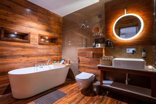 Un baño con bañera, inodoro y lavabo. en Indulge McLeodganj by Pack, en Dharamsala