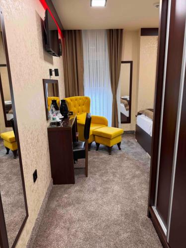 a hotel room with a yellow couch and a bedroom at Villa Aroma 2 in Orašje