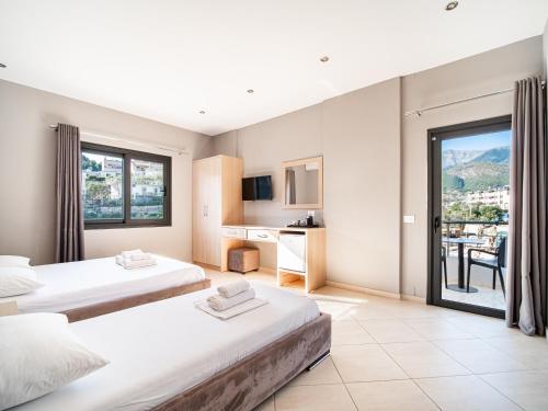 a hotel room with two beds and a balcony at Endless Blue Himara in Himare