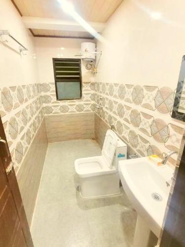a bathroom with a toilet and a sink at Nehal Royal Homestay in Kalimpong
