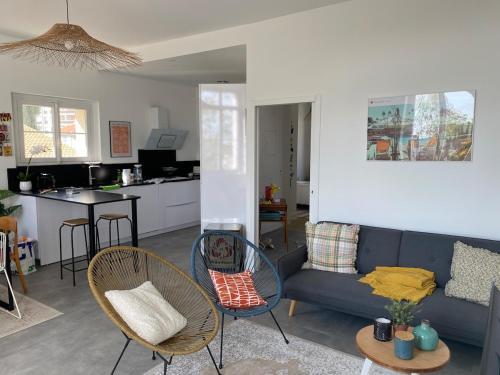 - un salon et une cuisine avec un canapé bleu et des chaises dans l'établissement Villa Louise à 500 m des plages, à Royan