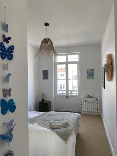 - une chambre avec un lit aux papillons sur le mur dans l'établissement Villa Louise à 500 m des plages, à Royan
